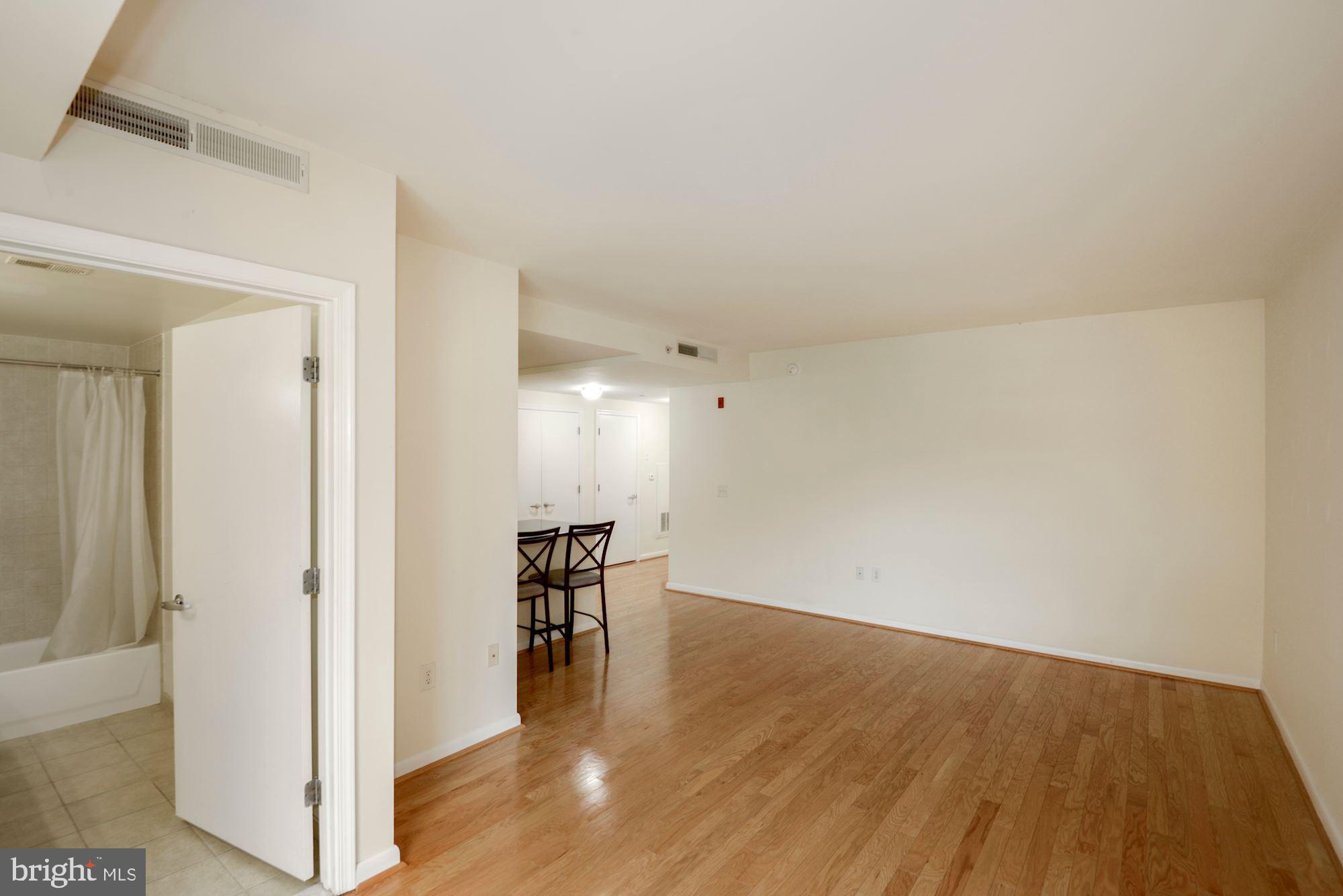 355 I Street Southwest, Unit S607 Washington, DC 20024 - Photo 6 of 27 a view of a livingroom with wooden floor and a kitchen space