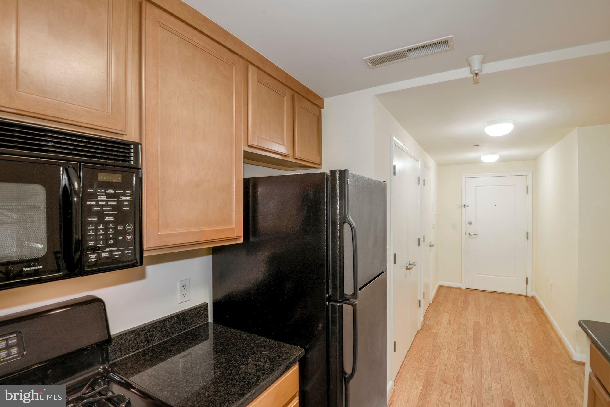 355 I Street Southwest, Unit S607 Washington, DC 20024 - Photo 9 of 27 a kitchen with a refrigerator and a stove top oven