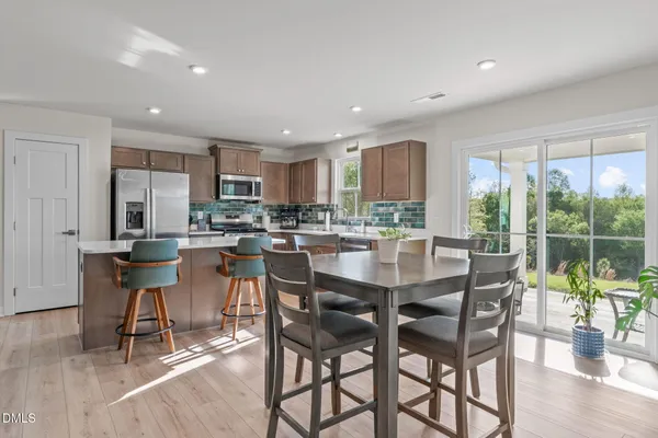a kitchen with stainless steel appliances granite countertop table chairs and view living room