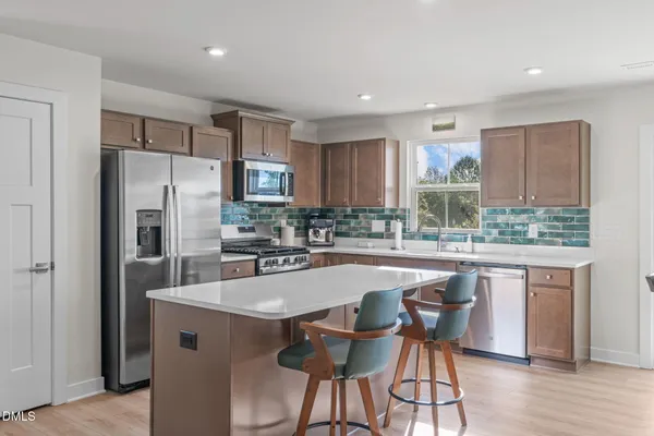 a kitchen with granite countertop a center island stainless steel appliances cabinets and a window