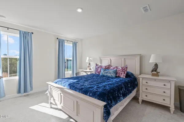 a bedroom with a large bed and a dresser