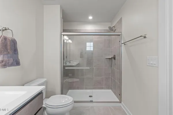 a bathroom with a shower a toilet and a sink