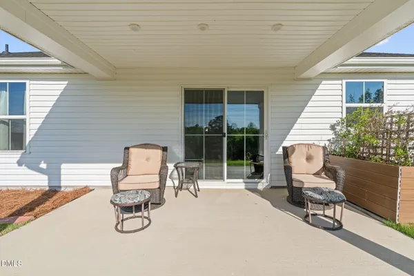 a view of a chairs and table in patio with a backyard