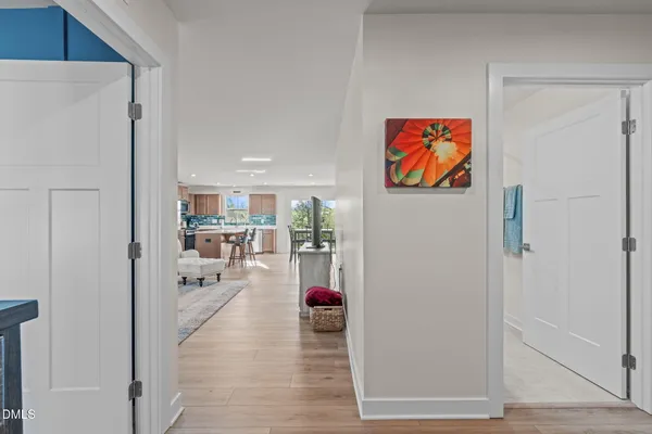 a view of a hallway with wooden floor and a living room