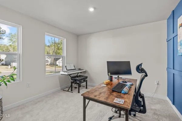 a view of a workspace with furniture and a window