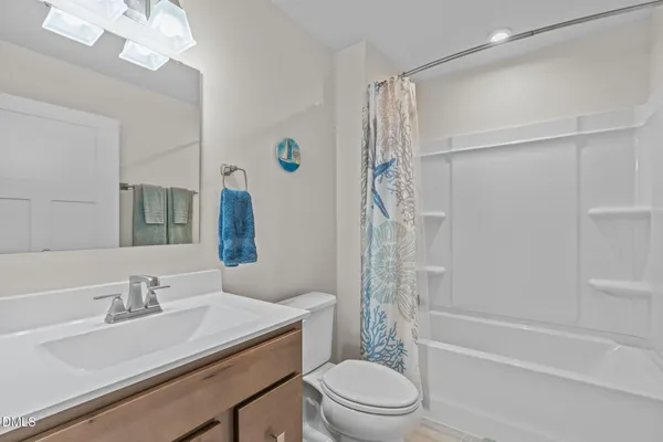 a bathroom with a sink toilet vanity and shower