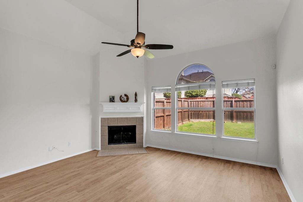 447 Trinity Drive Allen, TX 75002 - Photo 11 of 24 a view of an empty room with a fireplace and a window