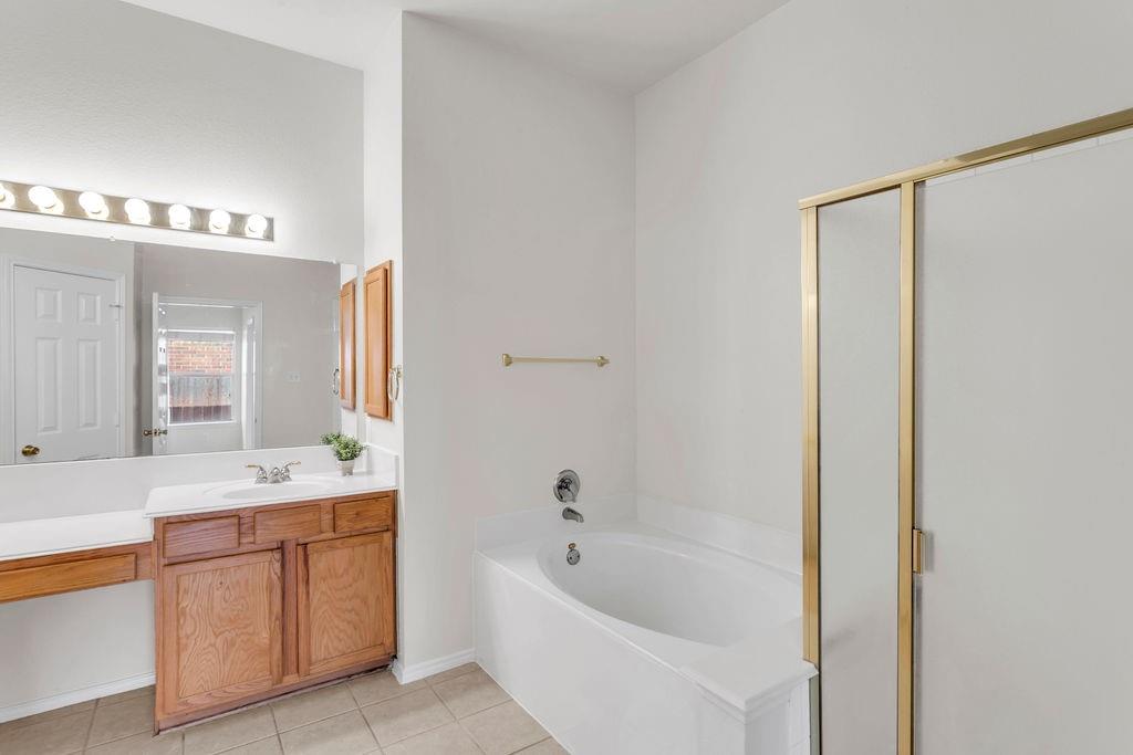 447 Trinity Drive Allen, TX 75002 - Photo 19 of 24 a bathroom with a tub a sink and a window