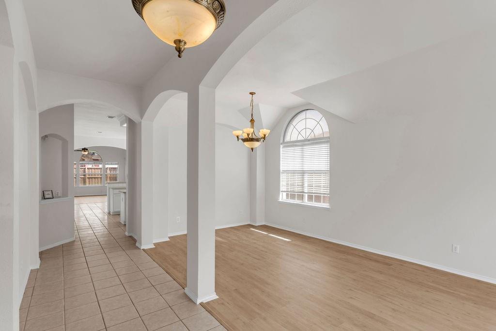 447 Trinity Drive Allen, TX 75002 - Photo 3 of 24 a view of an empty room with wooden floor and a window