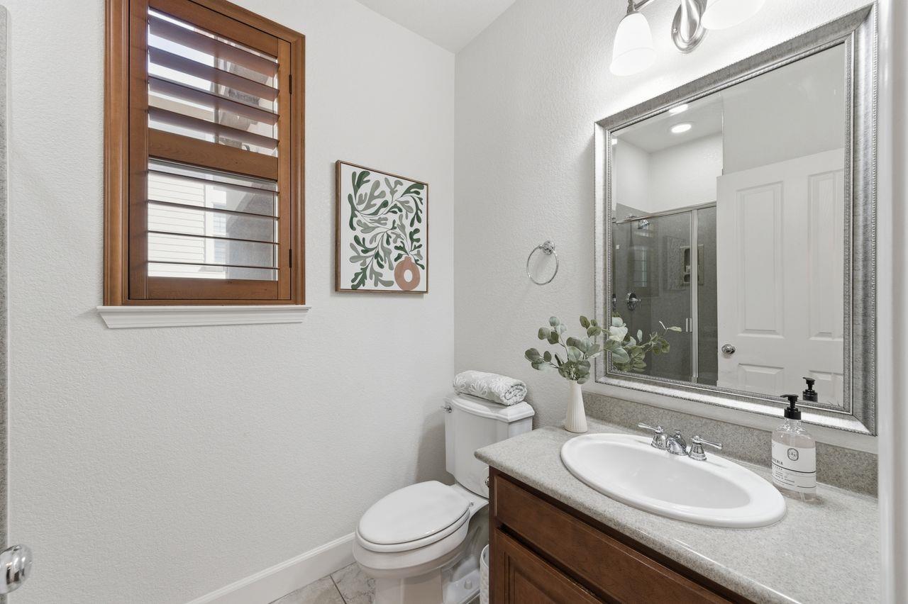 698 West Rico Way Tracy, CA 95391 - Photo 17 of 38 a bathroom with a granite countertop sink toilet a mirror and a shower