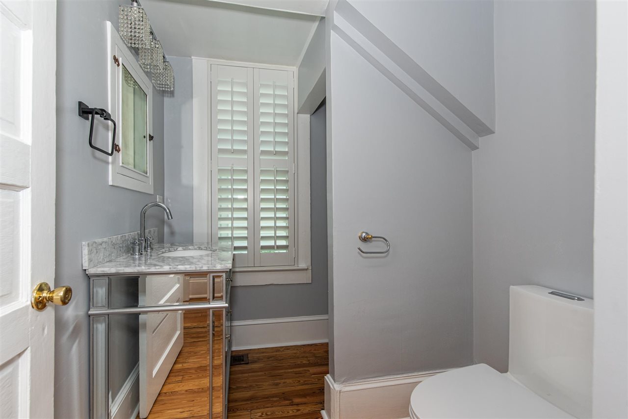 21 Saragossa Street St. Augustine, FL 32084 - Photo 27 of 46 a bathroom with a granite countertop sink a toilet and shower