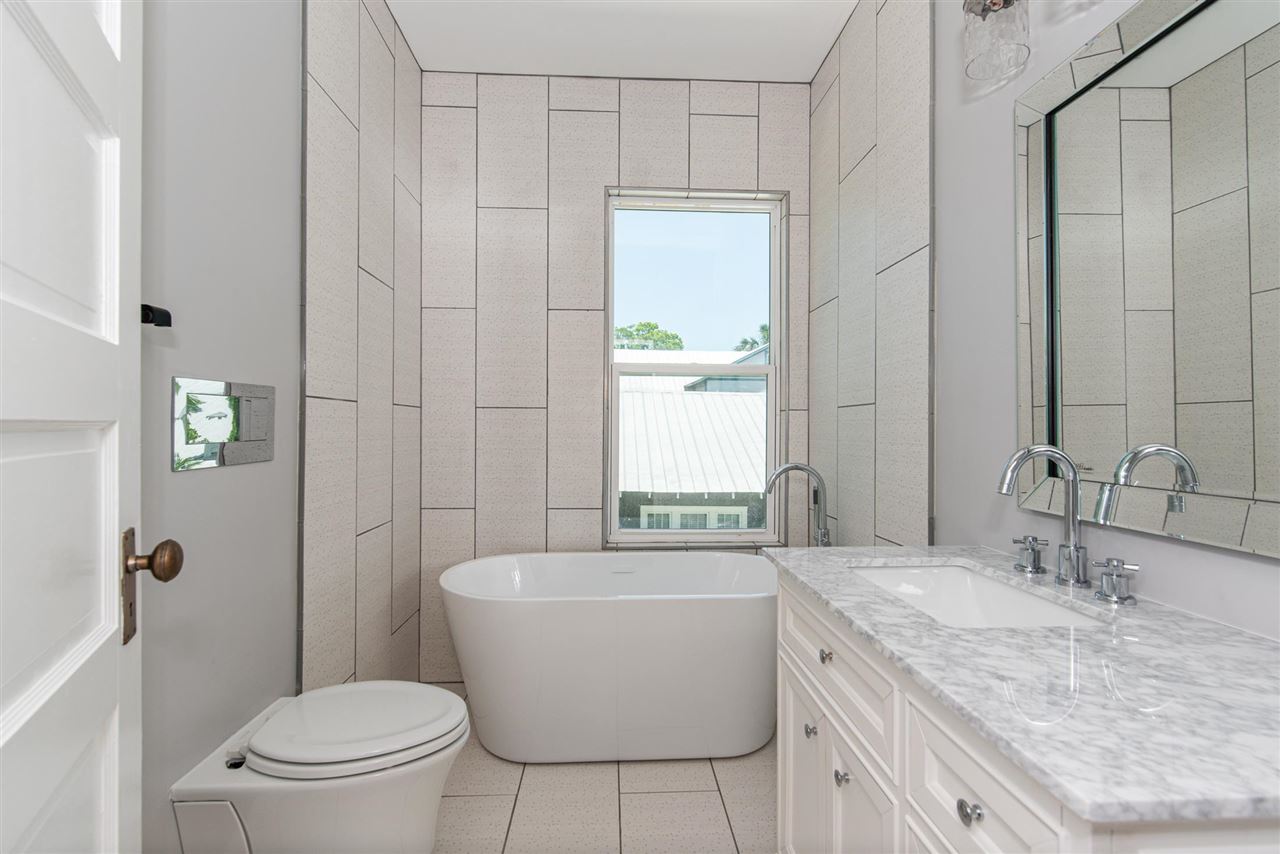 21 Saragossa Street St. Augustine, FL 32084 - Photo 37 of 46 a bathroom with a granite countertop sink mirror vanity and toilet