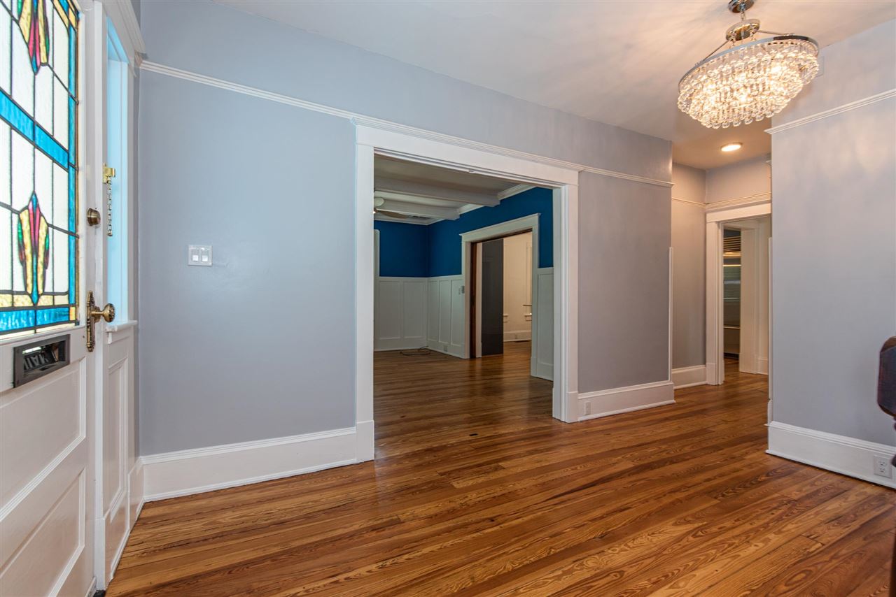 21 Saragossa Street St. Augustine, FL 32084 - Photo 9 of 46 a view of a hallway with wooden floor and a chandelier