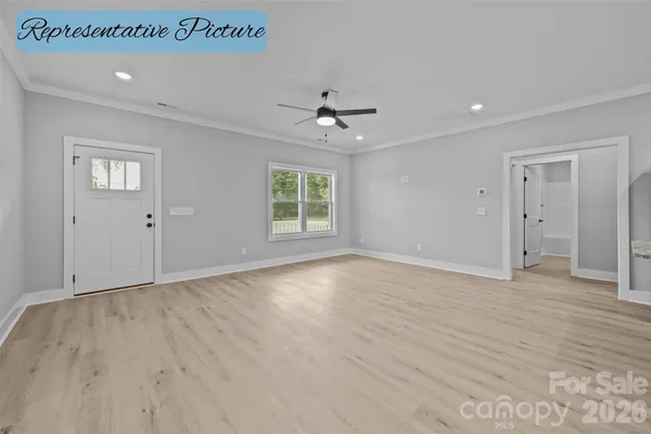an empty room with wooden floor ceiling fan and windows