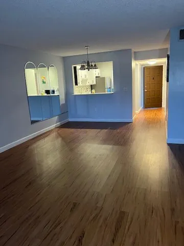 a view of an empty room and window with wooden floor
