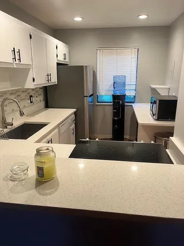 a kitchen with stainless steel appliances granite countertop a sink and a refrigerator