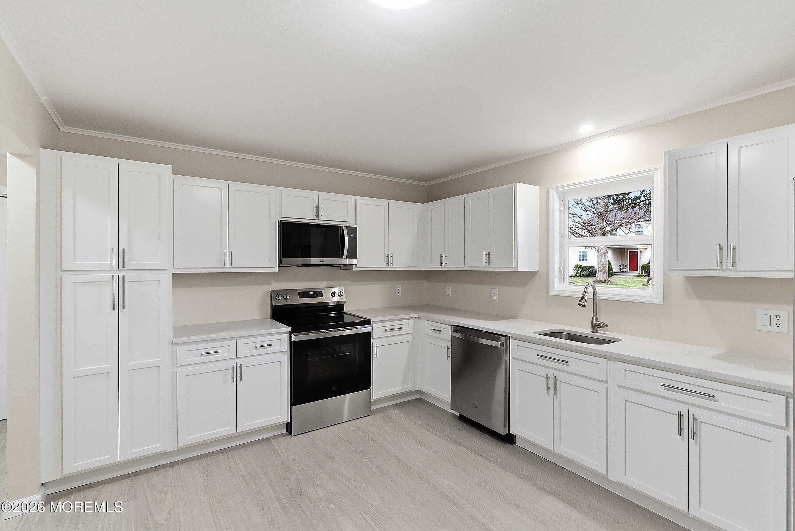 2710 Johnson Street Wall, NJ 07719 - Photo 10 of 38 a kitchen with white cabinets sink and stainless steel appliances