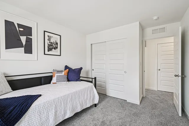 a bedroom with a bed and cabinet