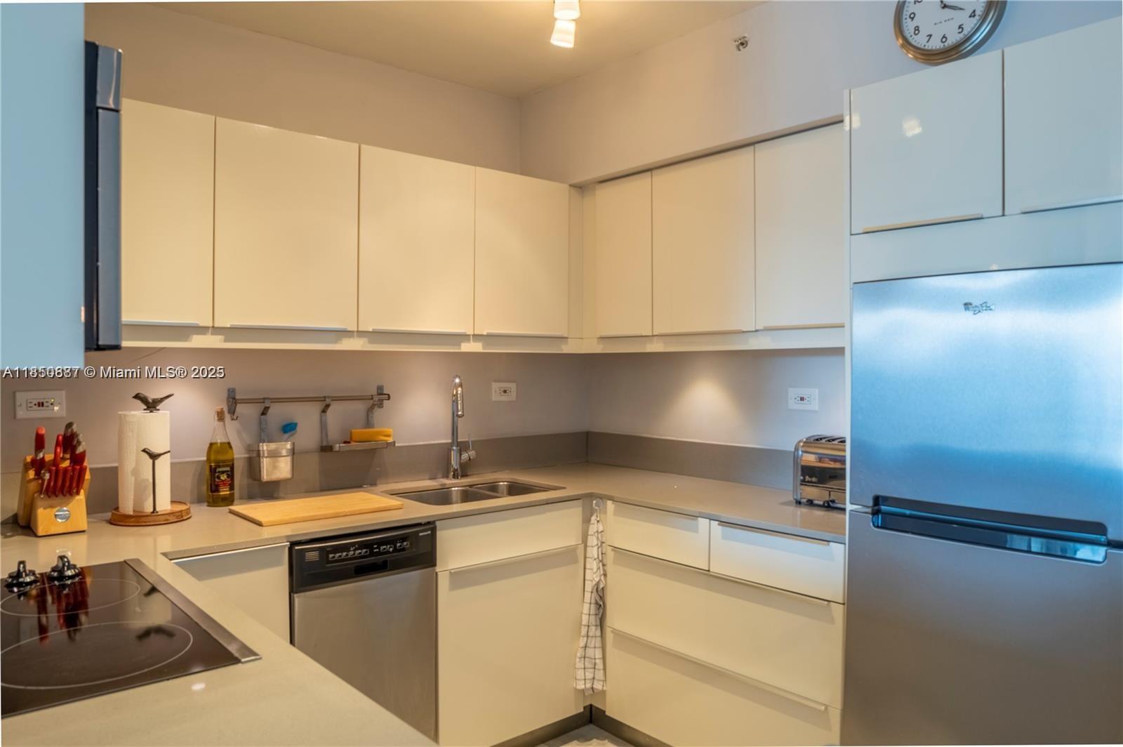 1500 Bay Road, Unit 1464S Miami Beach, FL 33139 - Photo 5 of 13 a kitchen with stainless steel appliances white cabinets and a sink