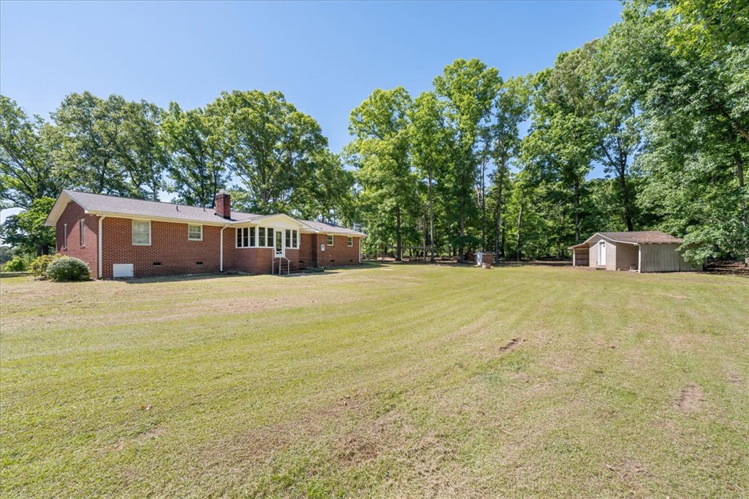 304 Shaw Road Honea Path, SC 29654 - Photo 34 of 39 Expansive green grounds surround this classic brick home, offering a tranquil retreat with ample outdoor space.