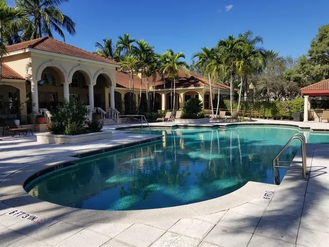 a view of a house with pool plants and large trees