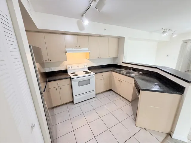 a kitchen with a stove sink and cabinets