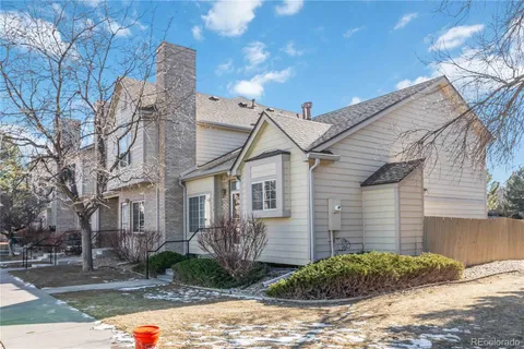 a view of a brick house with a yard and large tree