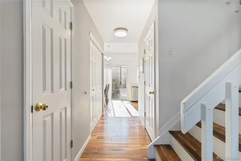 a view of a hallway with wooden floor and staircase