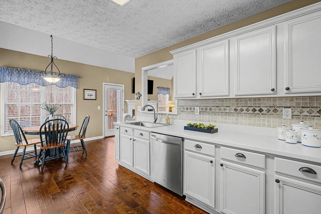 218 Amaranth Court Ball Ground, GA 30107 - Photo 12 of 39 a kitchen with stainless steel appliances granite countertop a white cabinets and wooden floor