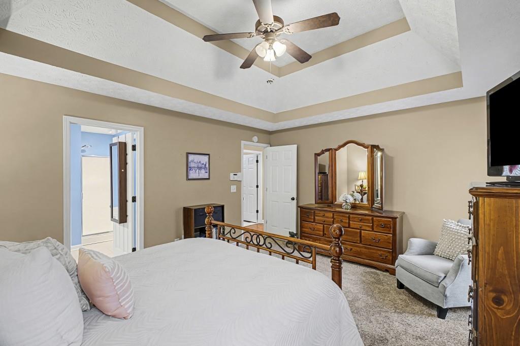 218 Amaranth Court Ball Ground, GA 30107 - Photo 19 of 39 a bedroom with a bed a dresser and flat screen tv