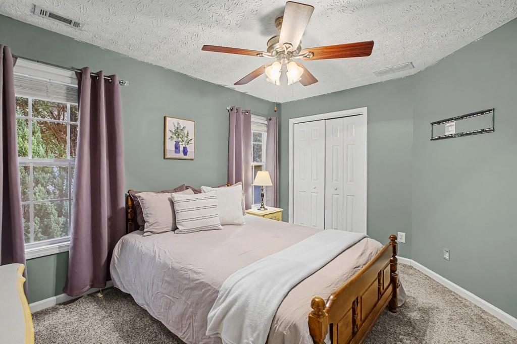 218 Amaranth Court Ball Ground, GA 30107 - Photo 24 of 39 a bedroom with a bed and a chandelier