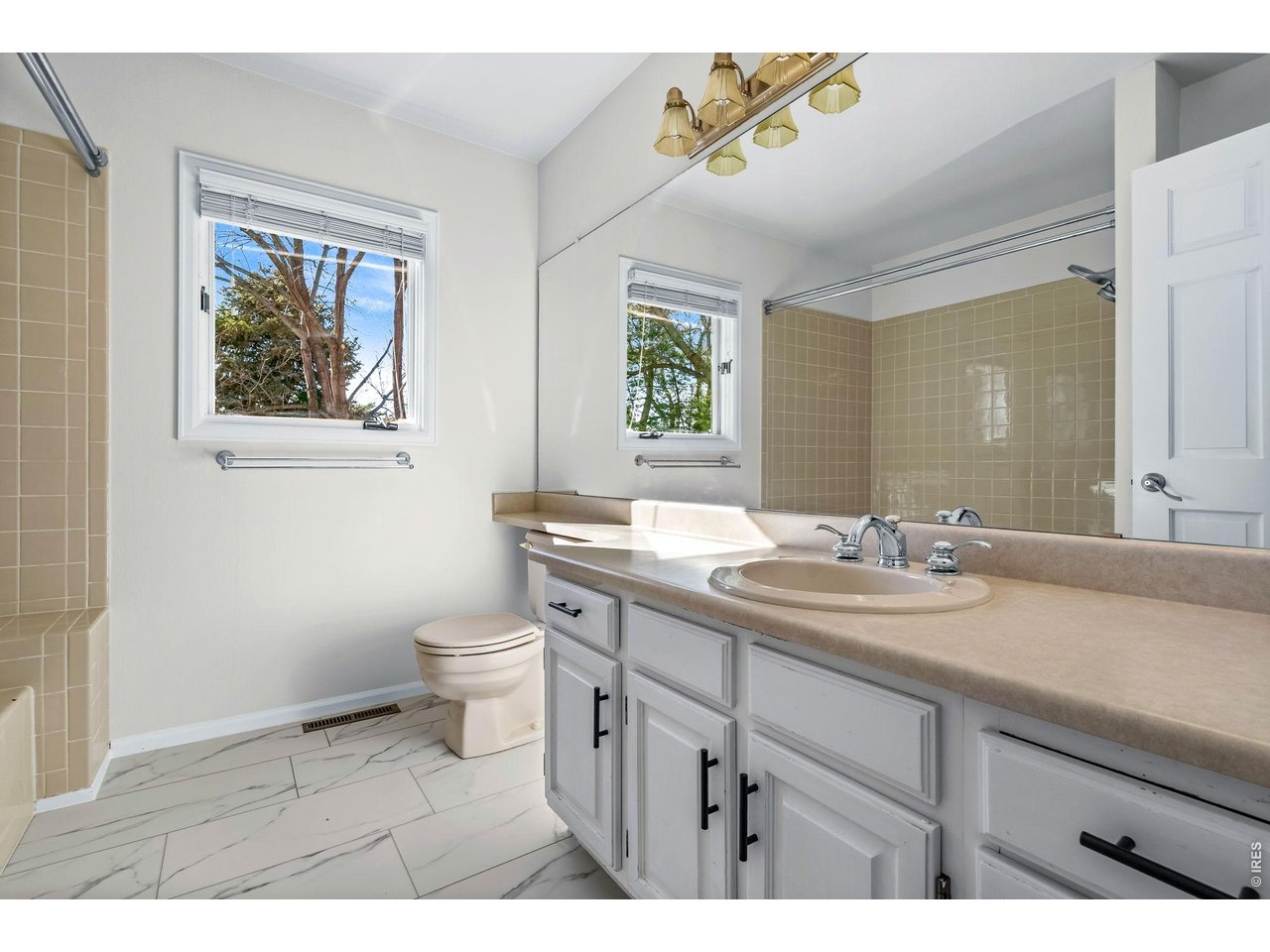 4133 Sumter Square Fort Collins, CO 80525 - Photo 21 of 42 a bathroom with a granite countertop sink a toilet a mirror and a window