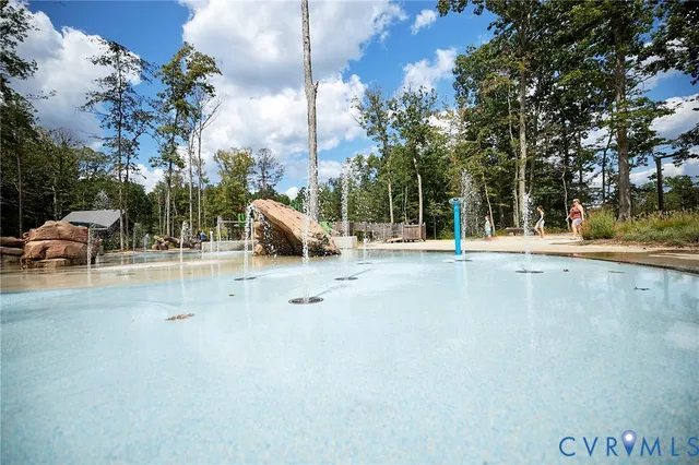 a view of white house with a yard and trees in the background