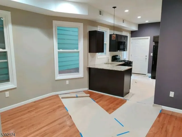a view of kitchen with stainless steel appliances kitchen island sink refrigerator and fireplace
