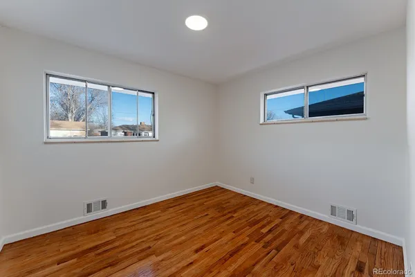 a view of empty room with wooden floor