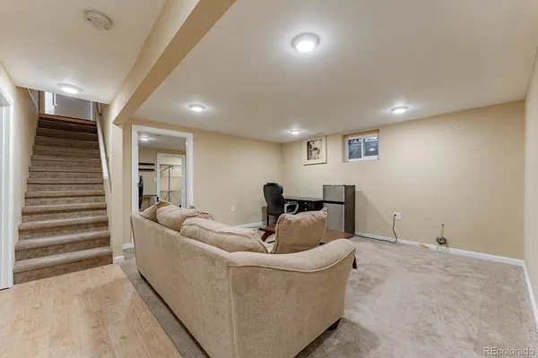 a living room with furniture and a wooden floor