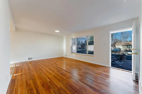 a view of empty room with wooden floor