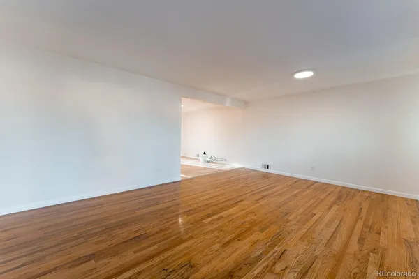 a view of empty room with wooden floor