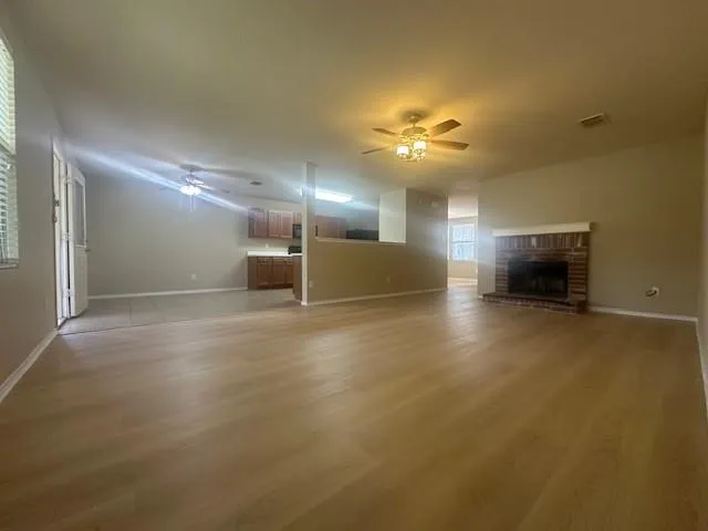 an empty room with a empty space and a kitchen view