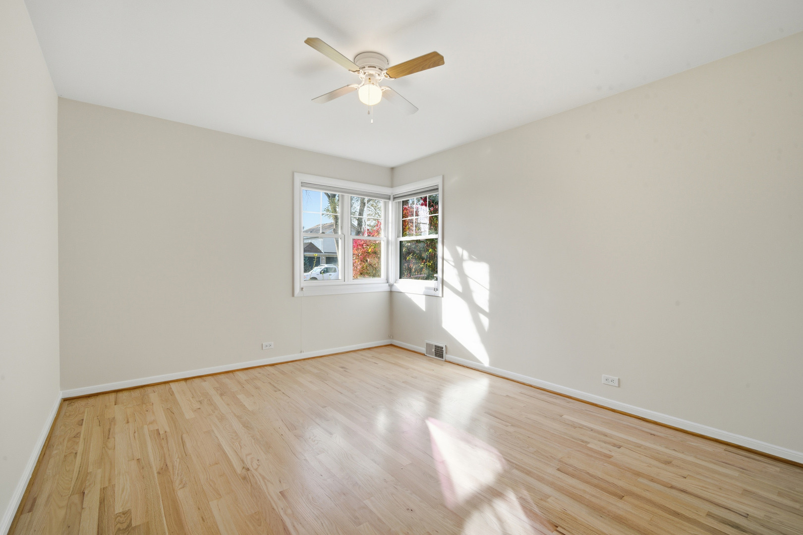 1700 Marguerite Street Park Ridge, IL 60068 - Photo 23 of 44 an empty room with wooden floor chandelier fan and windows