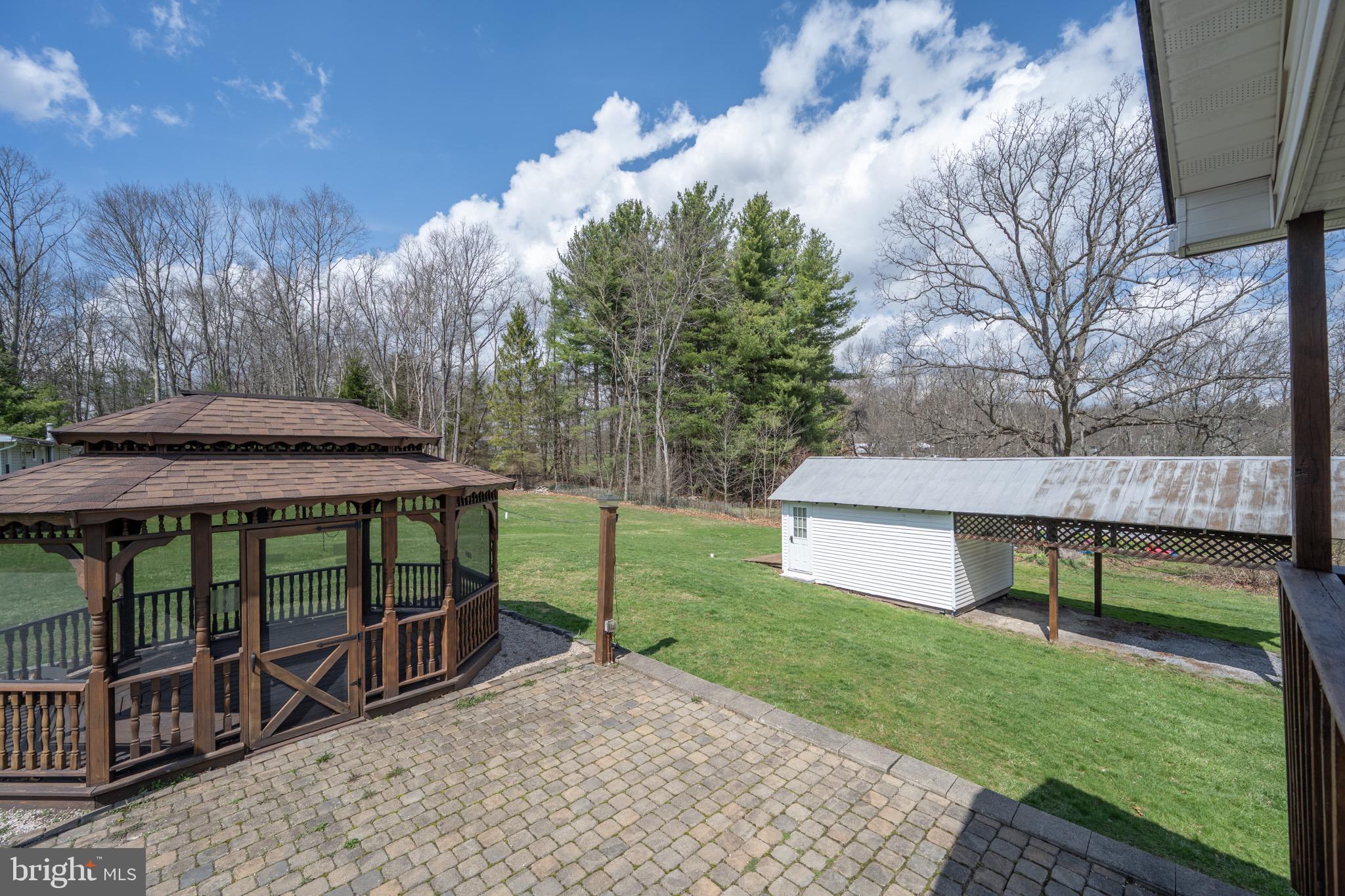 18 Ollie North Road Oakland, MD 21550 - Photo 38 of 48 a view of a patio with a table and chairs under an umbrella with large trees