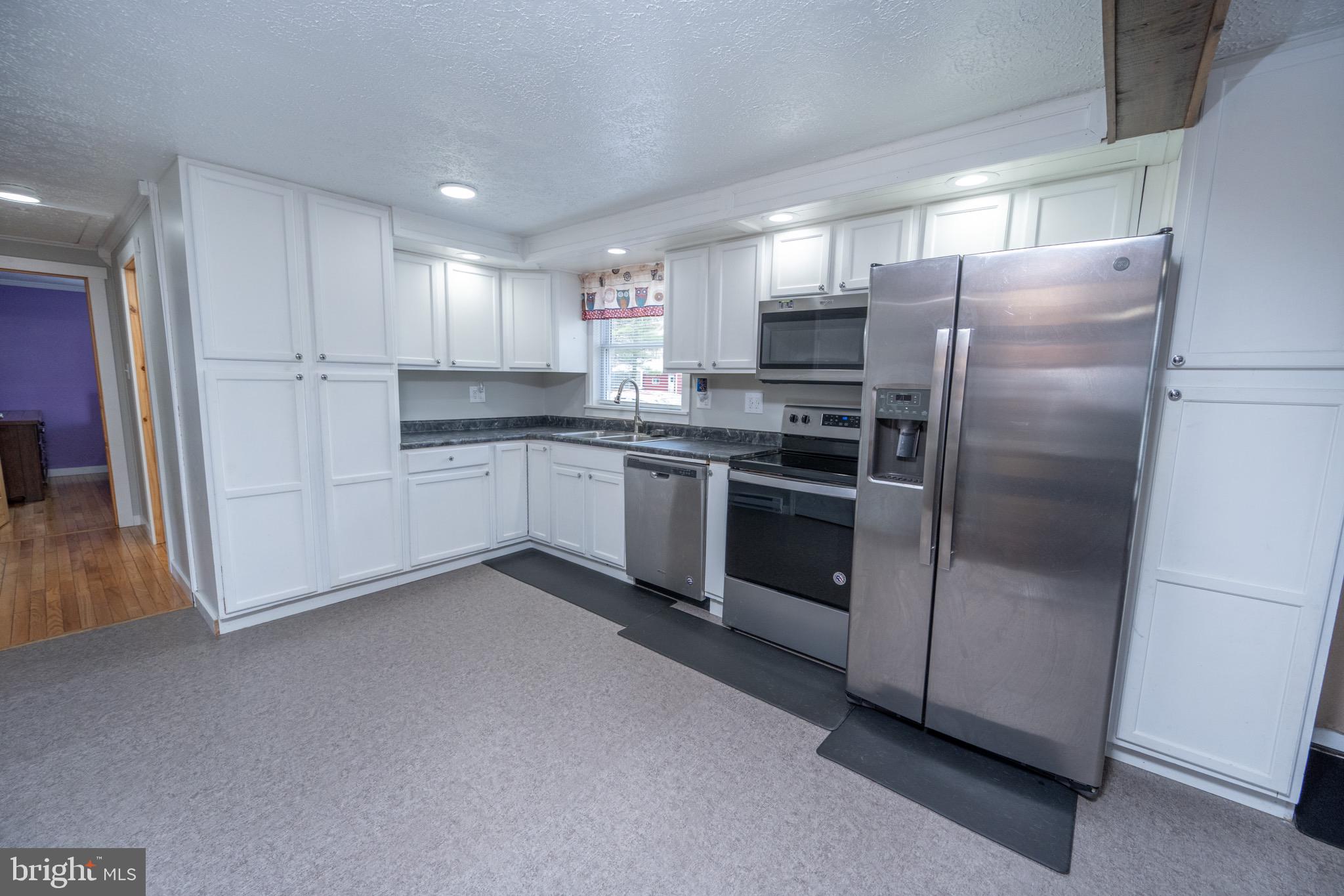 18 Ollie North Road Oakland, MD 21550 - Photo 5 of 48 a kitchen with stainless steel appliances granite countertop a refrigerator a sink a stove and white cabinets