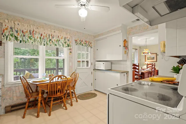 a kitchen with stainless steel appliances granite countertop a table chairs and a refrigerator