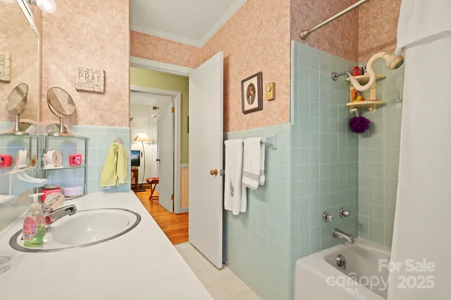 a bathroom with a sink a tub and shower curtain
