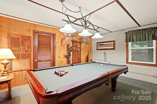 a room with pool table and windows