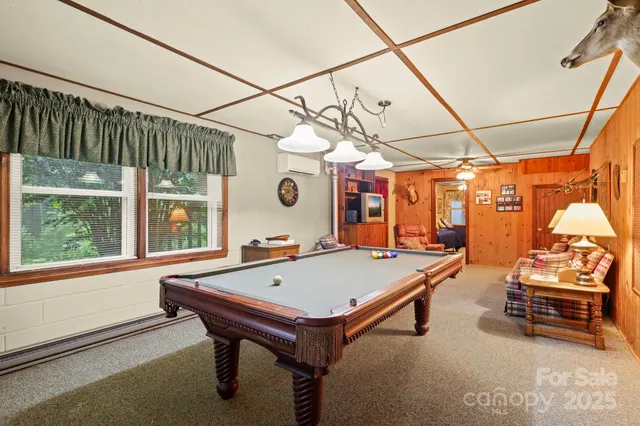 a room with pool table and windows