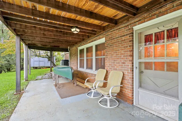 a porch with a bench and a yard
