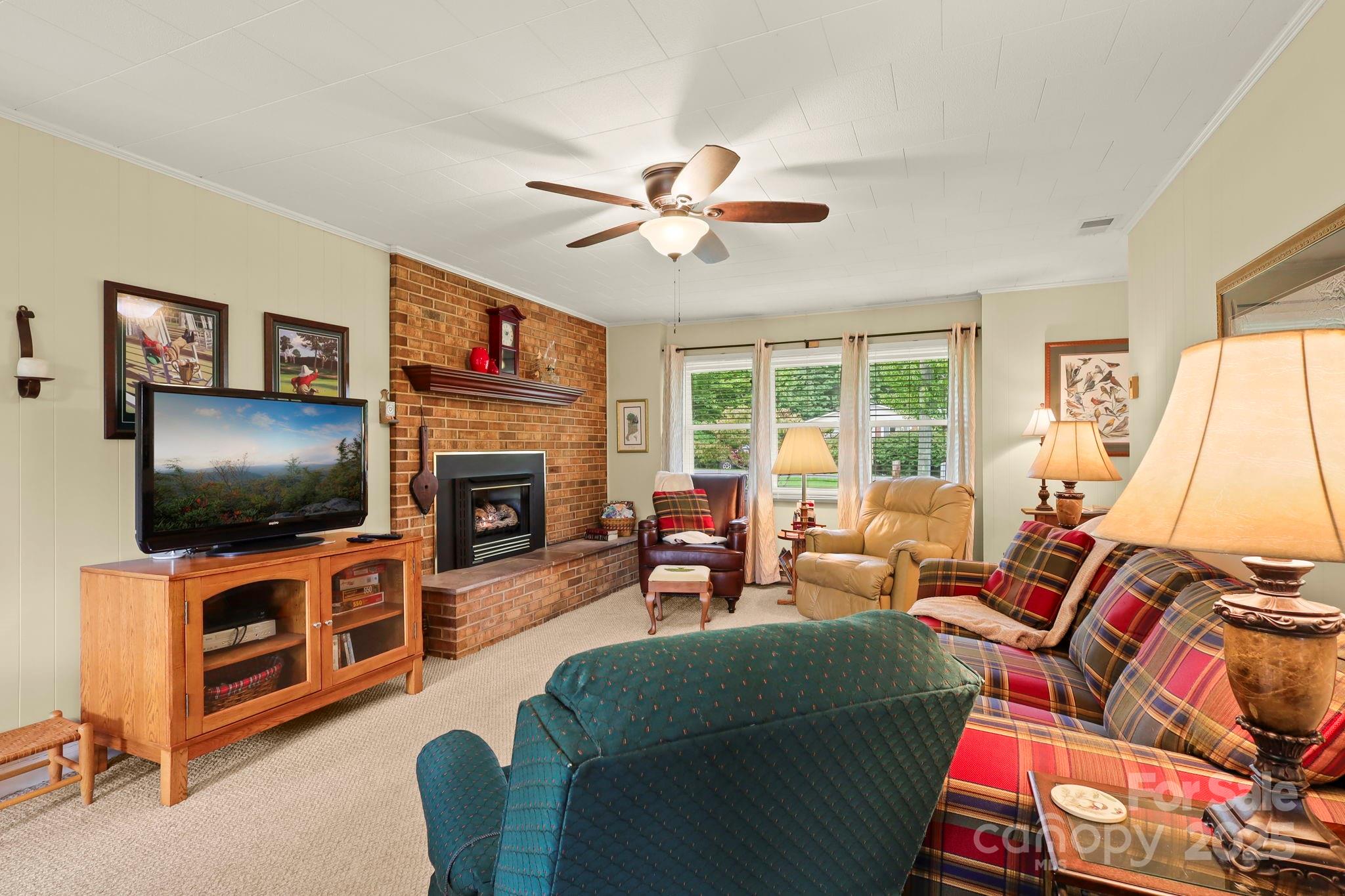 1074 Nikanor Road West Jefferson, NC 28694 - Photo 8 of 45 a living room with furniture a flat screen tv and a fireplace