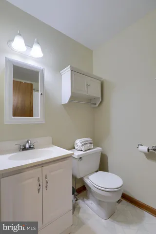 a bathroom with a toilet sink vanity and mirror