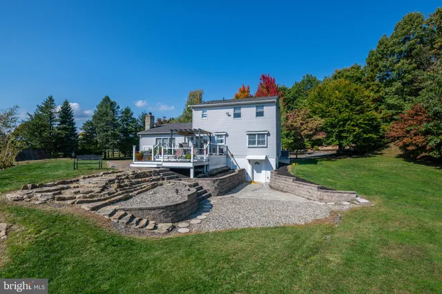 a view of a house with backyard and sitting area